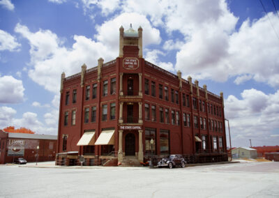 Historic red brick building with vintage architecture under a partly cloudy sky.
