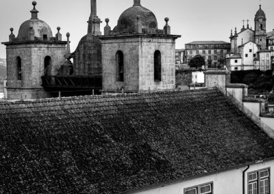 Black and white photo of historic European rooftop with domes and crosses.