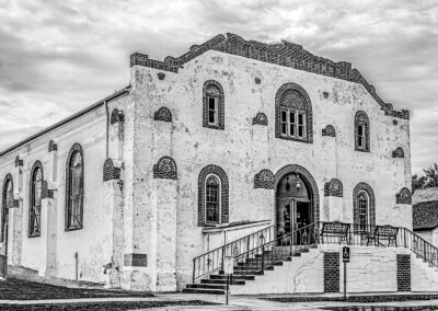 Historic stone building with arched windows and entrance steps.