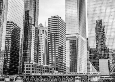 Black and white photo of a city skyline with tall skyscrapers and a bridge.