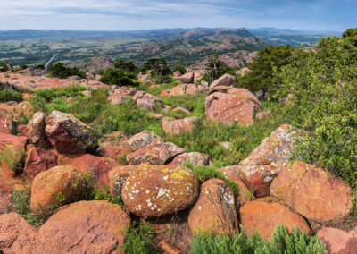 Rocky landscape with green vegetation under a clear blue sky.