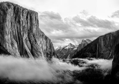 Black and white photo of a mountainous landscape with clouds.