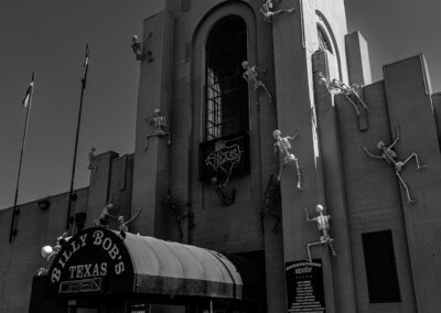 Black and white image of Billy Bob's Texas entrance with figures climbing the building.