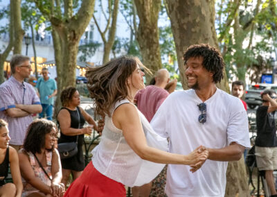 Couple joyfully dancing outdoors at a lively event.