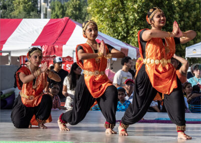 Young dancers in traditional attire perform a cultural dance outdoors.