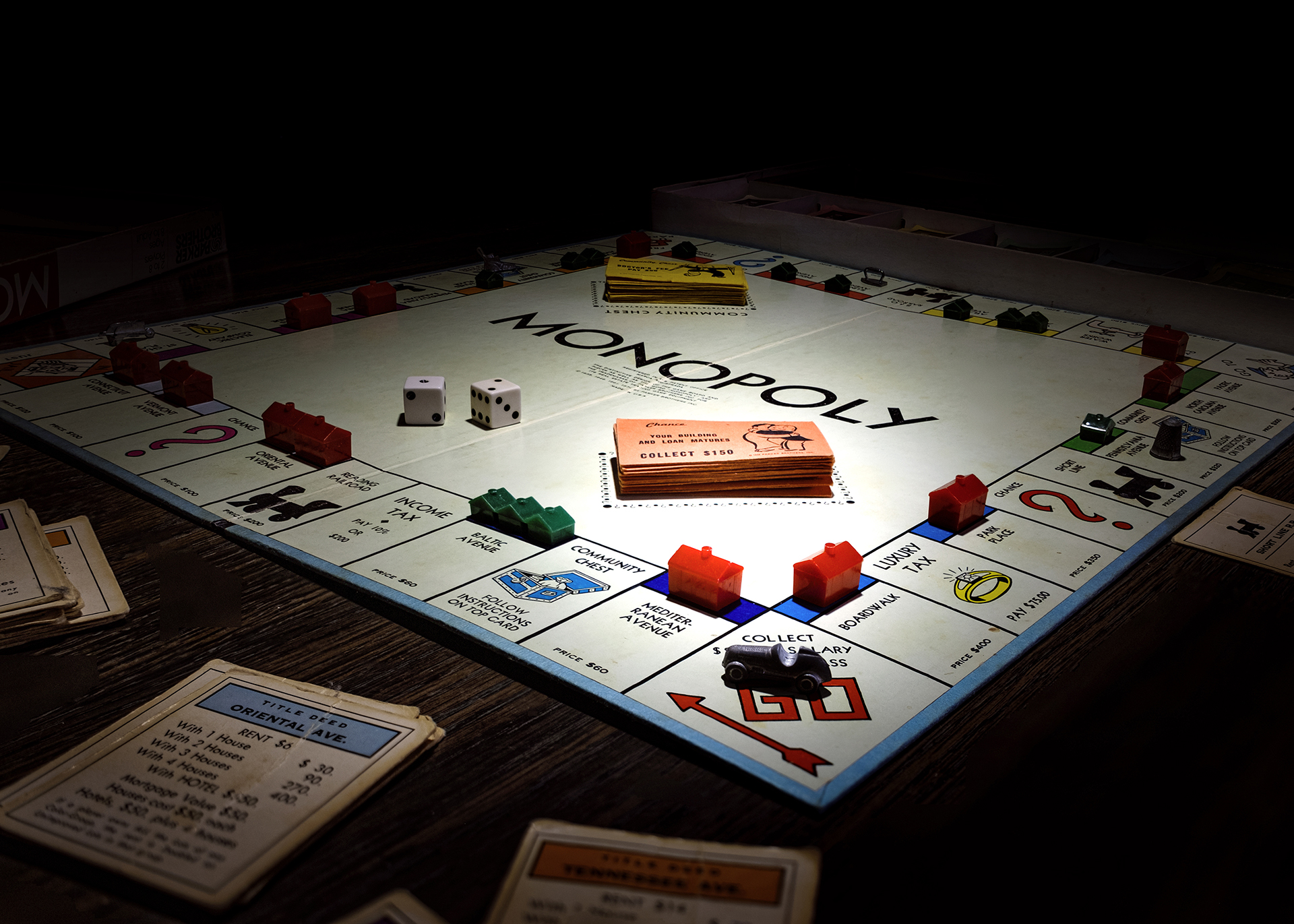 Classic Monopoly board game setup with houses, dice, and money.
