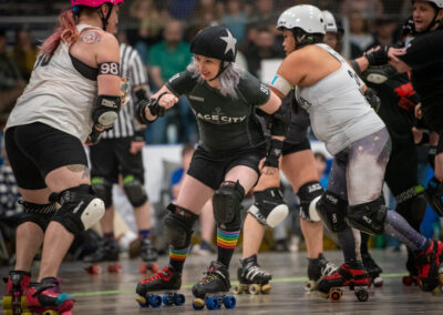 Roller derby players compete intensely on the track during a match.