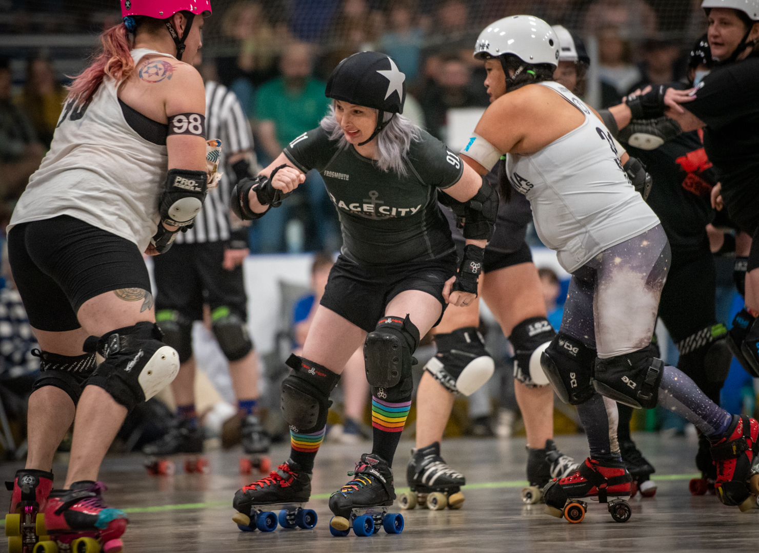 Roller derby players compete intensely on the track during a match.